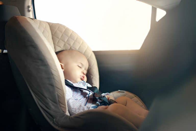 bébé entrain de dormir en voiture avec du soleil à la fenetre