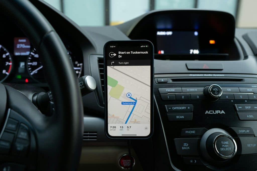 Téléphone fixé sur un support magnétique dans une voiture avec application GPS active pour guider le conducteur