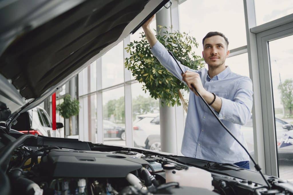 Inspection mécanique d'une voiture d'occasion dans un garage français, capot ouvert