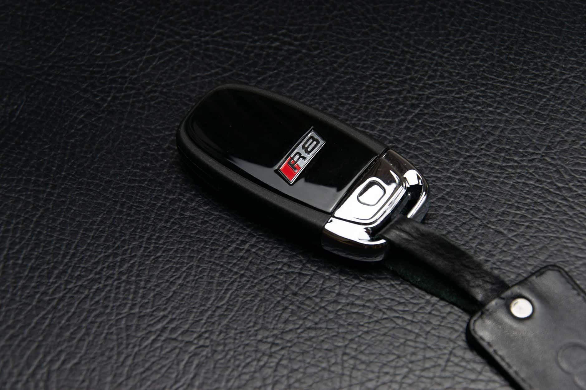 Clé voiture pressée contre bouton Start Stop pour démarrer sans pile