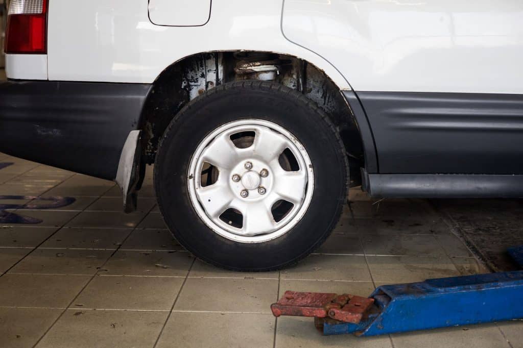 Pneu 215/50 R17 posé en station debout dans un garage, vue de profil