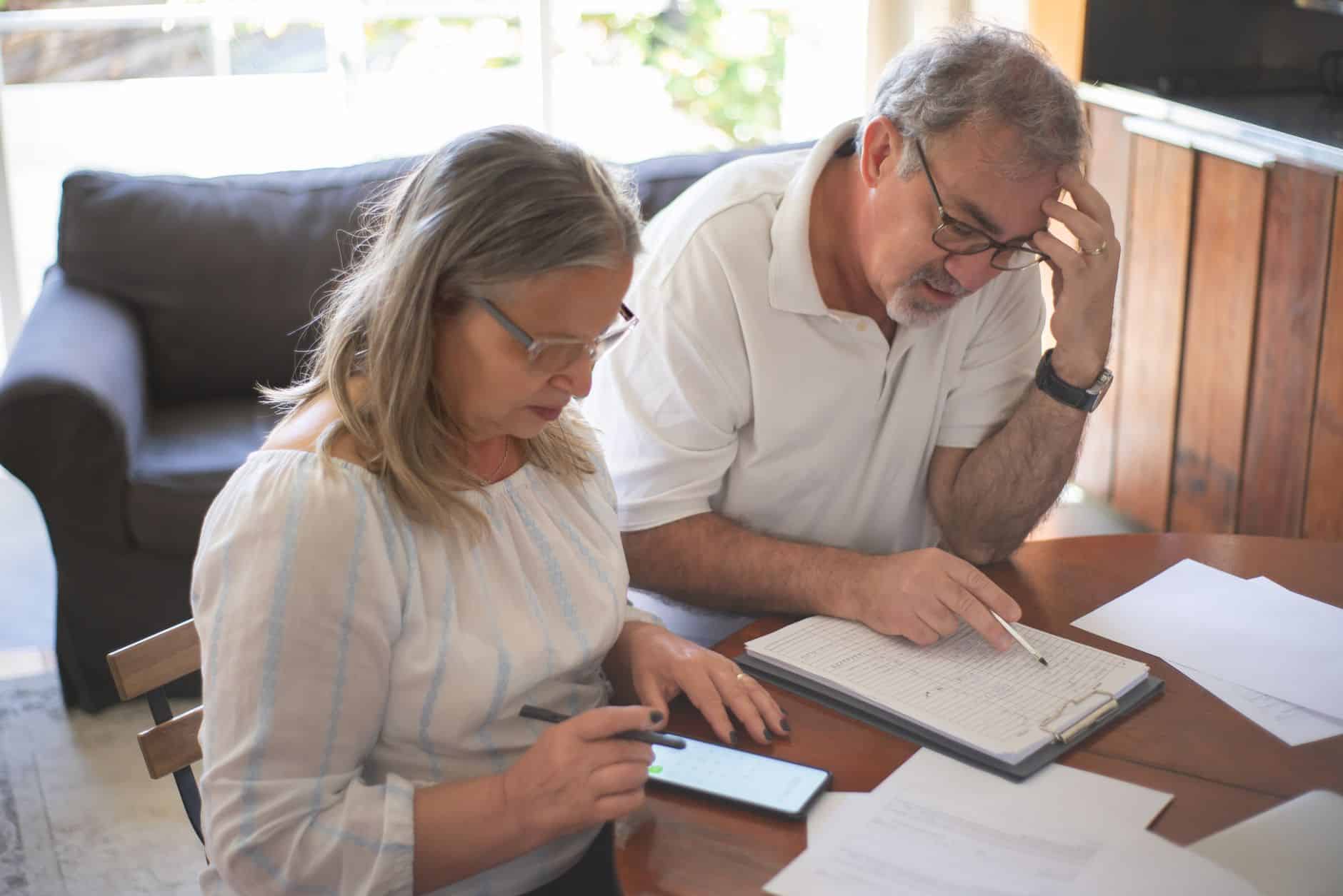 Couple senior calculant budget achat camping-car en concession